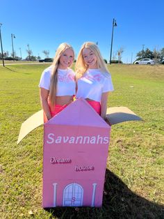 two girls are standing in front of a cardboard house with the words savannahns on it