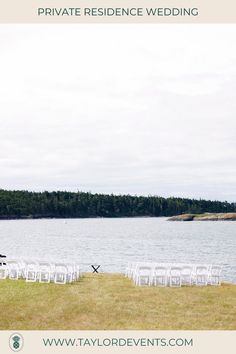 a row of white chairs sitting on top of a grass covered field next to a lake