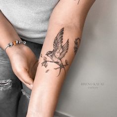 a woman with a bird tattoo on her arm