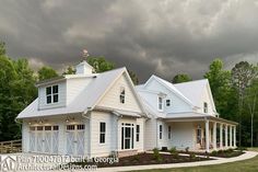 a large white house sitting on top of a lush green field under a cloudy sky