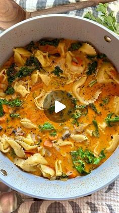 a pot filled with pasta and broccoli on top of a table