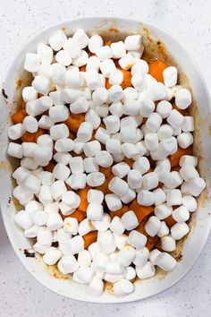 a white bowl filled with marshmallows on top of a table