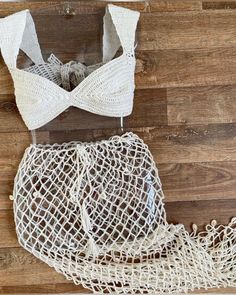 a white piece of cloth sitting on top of a wooden floor next to a string bag