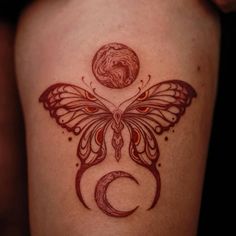 a woman's thigh with a butterfly and moon tattoo on the side of her leg