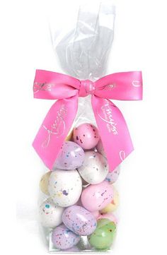 a bag filled with lots of different colored easter eggs and a pink bow on top