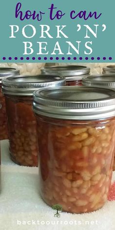 jars filled with beans sitting on top of a white cloth covered table next to a red and blue sign that says how to can pork'n beans