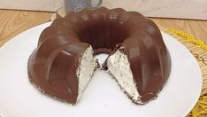 a chocolate bunt cake on a white plate with one piece cut out and ready to be eaten