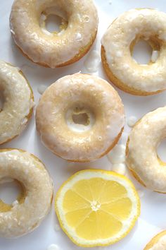 several glazed donuts with icing and lemon slices