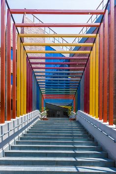 the stairs are painted bright colors and have metal railings on each side that lead up to an entrance