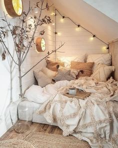 a bed with pillows, blankets and lights on the headboard in a loft bedroom