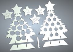 cut out paper christmas trees with stars on the top and bottom, in various sizes