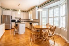 an empty kitchen and dining room with wood floors