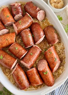 several sausages and rice in a white dish