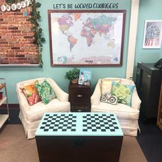 a living room with two chairs and a coffee table in front of a map on the wall