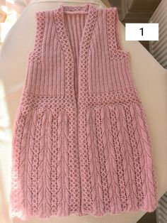 a pink knitted vest sitting on top of a table