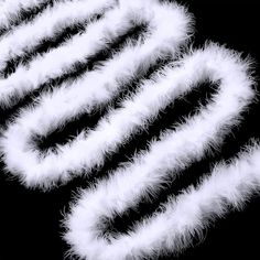 white feathers are arranged in the shape of an x on a black background with space for text