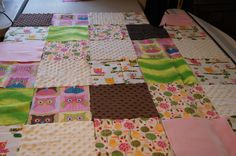 a quilted table cloth with owls and owl designs on the top, sitting on a bed