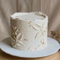 a white cake sitting on top of a plate