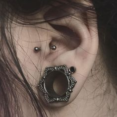 a close up of a person with ear piercings on their ears and behind the ear