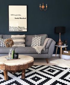 a living room filled with furniture and a large poster on the wall above it's coffee table