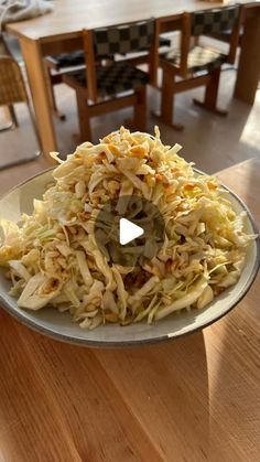 a bowl filled with food sitting on top of a wooden table