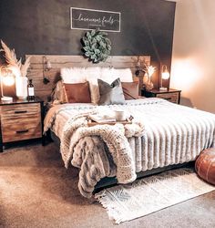 a bedroom with a bed, nightstands and pillows on the floor in front of a chalkboard wall