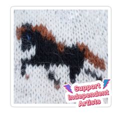 a close up of a knitted animal with the words support independent artists on it