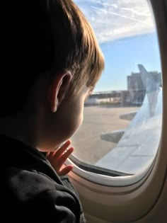 a young boy looking out an airplane window