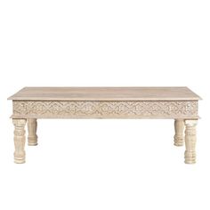 a white wooden table with carvings on the top and bottom, against a white background