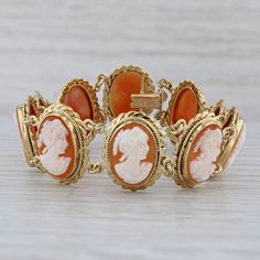 "Gemstone Information: - Natural Shell - Size - 13.5 x 10.5 mm Cut - Oval Carved Shell Color - Orange & White Metal: 18k Yellow Gold Weight: 23.3 Grams  Stamps: 750 Style: Oval Links Closure: Snap & Latch Inner Circumference: 6 3/4\" Width: 18.2 mm Each piece is thoroughly examined and refinished as needed by our professional jewelers, graded by our in-house GIA (Gemological Institute of America) Graduate Gemologist, and inspected for quality before being carefully packaged and promptly shipped. [SKU: A6594] phd" Antique Yellow Gold Bracelet For Formal Occasions, Antique Yellow Gold Bracelets For Formal Occasions, Exquisite Hallmarked Bracelet For Formal Occasions, Exquisite Hallmarked Bracelets For Formal Occasions, Elegant Yellow Gold Collectible Bracelets, Luxury Wedding Bracelet With Cabochon, Luxury Cabochon Bracelets For Wedding, Formal 14k Gold Bracelet, Luxury Cabochon Jewelry For Formal Occasions