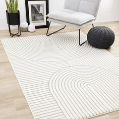 a white rug with an abstract design in the middle and a chair next to it