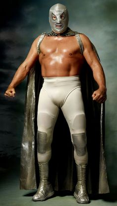 a man in a wrestler suit with his hands on his hips and wearing a mask