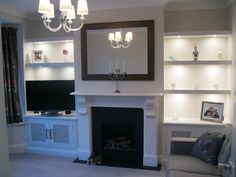 a living room filled with furniture and a fire place in front of a tv mounted on a wall