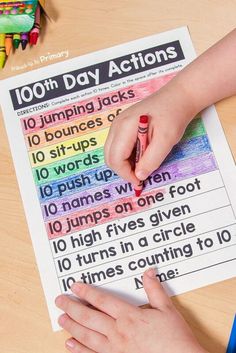 a child's hand writing on a piece of paper with the words 100th day actions