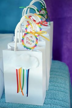 small gift bags with colorful ribbons on them