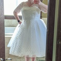 a woman in a white dress taking a selfie