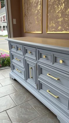 a blue dresser with gold handles and drawers