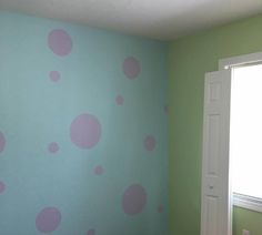 a room with green walls and pink polka dots on the wall