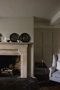 a living room filled with furniture and a fire place in front of a white fireplace