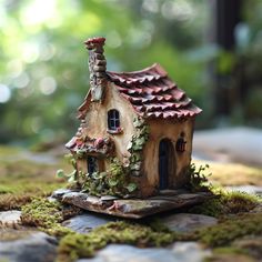 a small house made out of clay with ivy growing on it's roof and windows