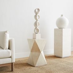 two white vases sitting next to each other on top of a carpeted floor