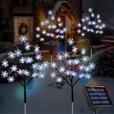 solar powered snowflake trees in front of a house