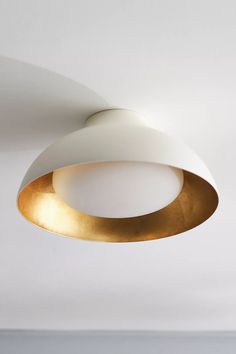 a white and gold ceiling light hanging from the ceiling in a living room or bedroom