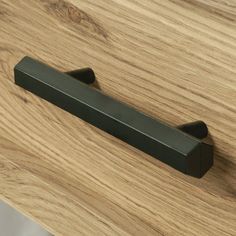 a close up of a drawer handle on a wooden surface