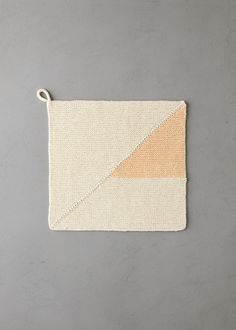 a piece of cloth hanging from a hook on a gray wall with an orange and white stripe