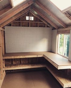 the inside of an unfinished room with wooden walls and shelves on either side of it