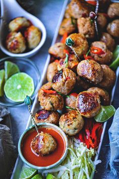 a platter filled with meatballs covered in sauce and garnished with lettuce