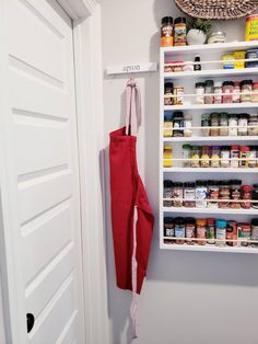 an open pantry door with spices and condiments on the shelves next to it