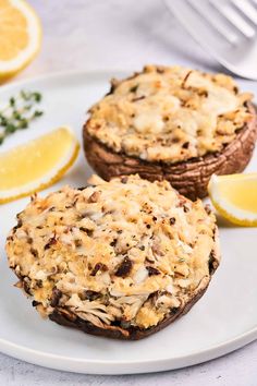 two muffins on a plate with lemon slices