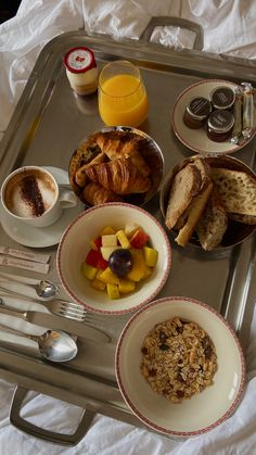 a tray filled with breakfast foods on top of a bed